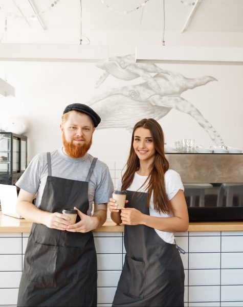 Coffee Business Concept - Portrait of small business partners standing together at their coffee shop